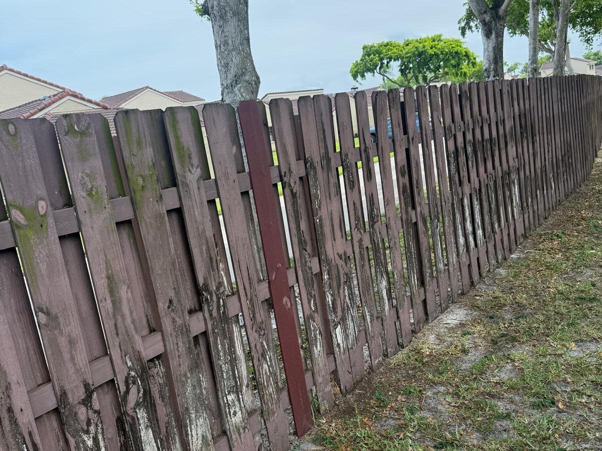 Weathered wood fence with mildew and peeling stain before restoration